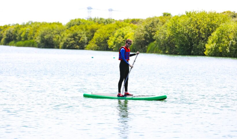SUP-ozás a Balatonon, nyugodt vízen egyensúlyozó evezős